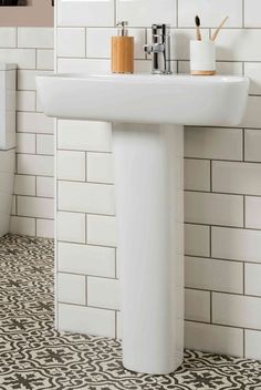 a white sink sitting next to a toilet in a bathroom