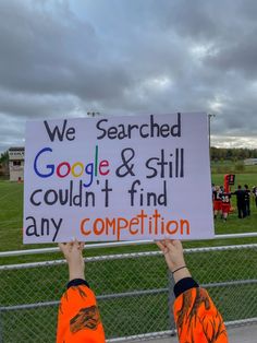 two people holding up a sign that says we search google & still couldn't find any competition