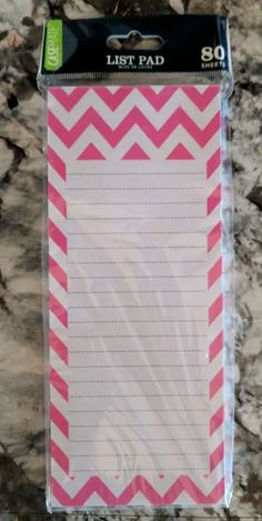 a pink and white chevroned notepad on a marble counter top with the word list pad printed on it