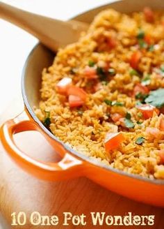 a pan filled with rice and vegetables on top of a wooden table