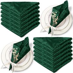 a stack of green napkins sitting on top of each other in front of a white plate