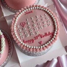 two birthday cakes with pink frosting and decorations