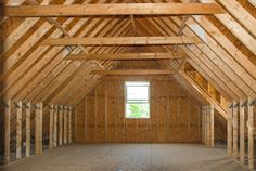 an attic with wooden framing and windows