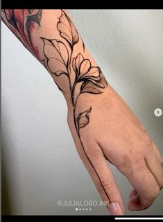 a person's hand with flowers on it and a flower tattoo on the wrist