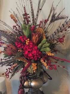 a vase filled with lots of red flowers on top of a table