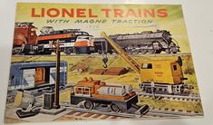 an old book with trains on the cover and other train related items in front of it