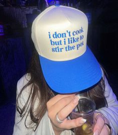 a woman wearing a blue and white hat with the words i don't cook but i like to stir the pot