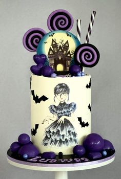 a three tiered cake decorated with purple and black decorations