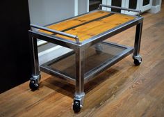 a metal and wood table sitting on top of a hard wood floor