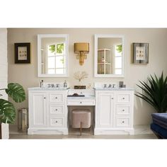 a bathroom with two sinks and mirrors on the wall next to a potted plant