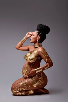 a woman sitting on the ground wearing gold glitters and holding her hand to her face