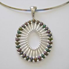 a silver necklace with multicolored beads on a white background