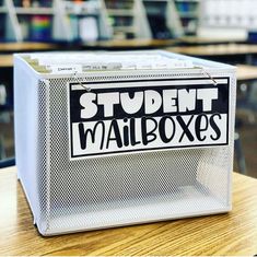 a white box sitting on top of a wooden table next to a pile of books