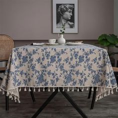 a blue and white table cloth with tassels sits on top of a chair