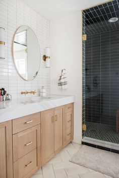 a bathroom with two sinks, a shower and a large mirror on the wall above it