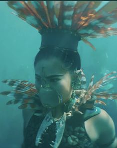 a woman with feathers on her head under water