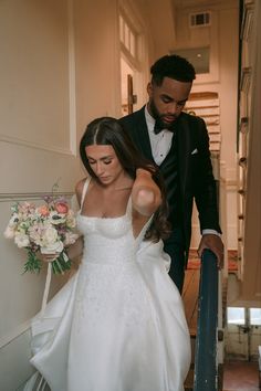 the bride and groom are walking down the stairs