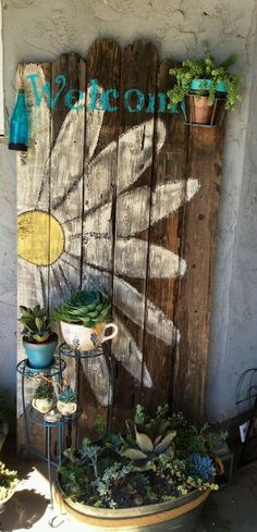 an old wooden fence with potted plants on it and a sign that says welcome