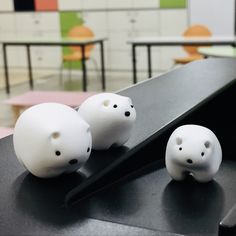 three white plastic animals sitting on top of a table