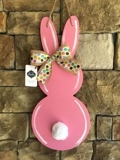 a pink bunny door hanger with polka dots and a bow on it's head