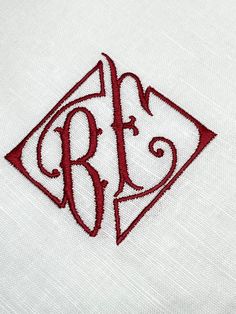 the monogrammed letter b is embroidered onto a white shirt with red stitching