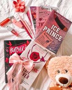 a teddy bear sitting on top of a bed next to books