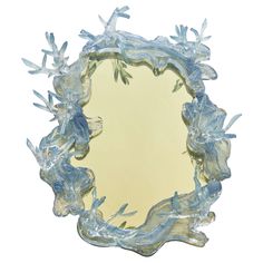 a mirror that is made out of glass and has frosted leaves on the edges