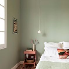 a bedroom with green walls and white bedding, two nightstands on either side