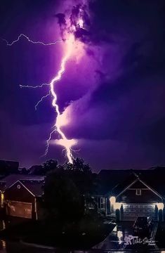 a lightning bolt is seen in the sky above houses