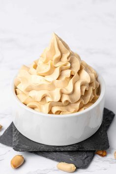 a white bowl filled with whipped cream on top of a table