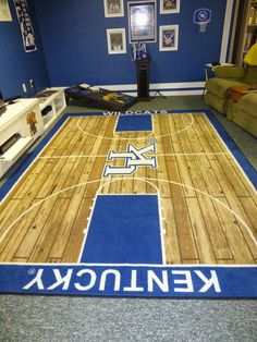 an indoor basketball court rug with the word kentucky on it in front of a couch