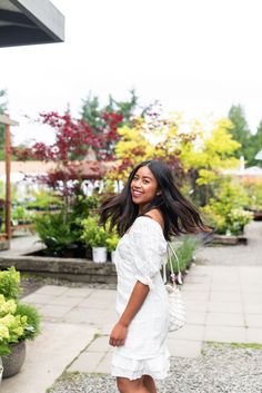 a woman in white is walking down the street