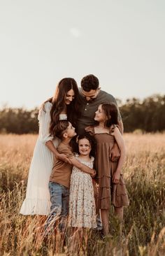 a family standing together in a field with tall grass