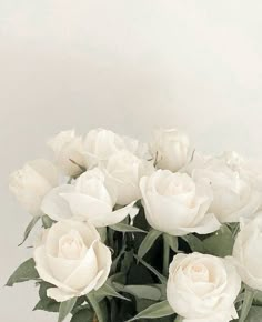 a vase filled with white roses on top of a table