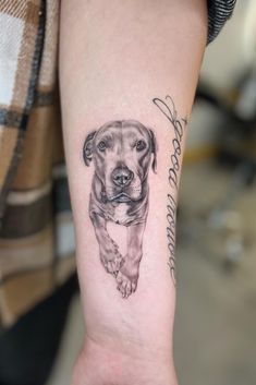 a dog tattoo on the arm of a woman's left arm, which has an image of a pitbull