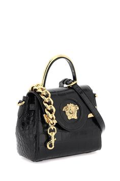 La Medusa handbag by Versace crafted in croco-embossed leather, featuring flap with magnetic button closure and the iconic metal Medusa head. Single handle with gold metal detail, removable chain shoulder strap and removable and adjustable crossbody shoulder strap in leather. Side straps, leather interior with an open flat pocket. Versace Gold finished metalware. Size Info STANDARD Color Detail Black Made In Italia Material 100% calf leather Season One spring Season Two summer Product bags Brand Luxury Evening Flap Bag With Gold-tone Logo, Evening Shoulder Bag With Gold-tone Logo And Double Handle, Designer Top Handle Shoulder Bag With Gold-tone Logo, Luxury Crossbody Flap Bag With Gold-tone Logo, Designer Top Handle Bag With Gold-tone Logo Plaque, Luxury Double Handle Shoulder Bag With Gold-tone Logo Plaque, Designer Top Handle Shoulder Bag With Metal Logo, Designer Shoulder Bag With Top Handle And Metal Logo, Luxury Crossbody Bag With Gold-tone Logo Plaque