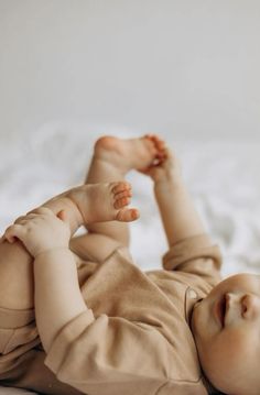 a small baby laying on top of a bed