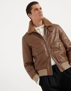 Polished calfskin aviator jacket with Thermore® padding and detchable shearling collar Refined Brunello Cucinelli materials and finishes enrich the beauty of this classic padded aviator jacket. The natural sheen of polished calfskin is paired with a soft, removable shearling collar and knit trim, creating a balanced mix of textures. The Thermore® padding ensures warmth and cozy comfort. Classic Brown Leather Jacket With Padded Collar, Classic Fitted Shearling Leather Jacket, Classic Brown Aviator Outerwear, Classic Brown Aviator Style Outerwear, Classic Leather Jacket For Work With Ribbed Collar, Classic Aviator Shearling Outerwear, Leather Aviator Outerwear With Faux Fur Lining, Classic Shearling Aviator Outerwear, Aviator Leather Jacket With Padded Collar For Fall