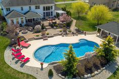 an aerial view of a large backyard with a pool and hot tub in the middle