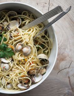 a bowl of pasta with clams and parsley