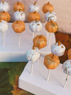 there are many cake pops that have been decorated with white and gold frosting on them