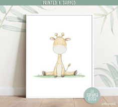 a giraffe is sitting on the ground in front of a wall with plants