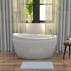 a white bath tub sitting on top of a hard wood floor next to a window