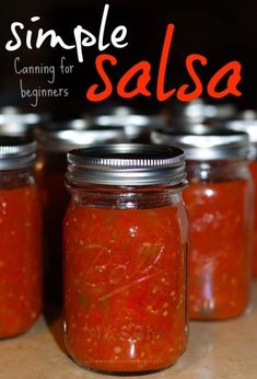 four jars filled with salsa sitting on top of a wooden table next to the words, simple canning for beginners salsa