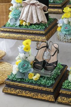 four pairs of shoes sitting on display in front of flowers