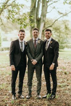 three men in suits standing next to each other