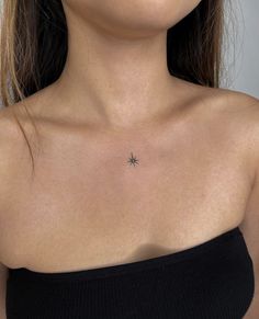 a woman's chest with a small star tattoo on the left side of her chest