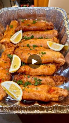 chicken wings with lemons and parsley in a pan