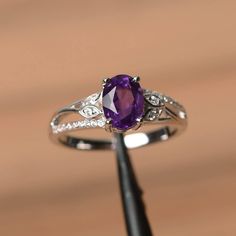 It is a natural amethyst ring. The main stone is 6 mm*8 mm oval cut.weight about 1.14 carats. The basic metal is sterling silver and plated with rhodium. To change the metal to a solid gold (white/rose) or platinum is also available, please ask for a quotation if you want. You can also go to my shop Home for more elegant rings: https://www.etsy.com/shop/godjewelry?ref=hdr_shop_menu Amethyst is the February birthstone . More amethyst rings: https://www.etsy.com/shop/godjewelry?section_id=20709248 Handfasting Ceremony, Purple Ring, Amethyst Ring Engagement, Ring Purple, Purple Amethyst Ring, Black Diamond Engagement, Wedding Plan, London Blue Topaz Ring, Black Diamond Ring Engagement