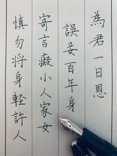 an ink pen and some writing on a piece of paper with chinese characters written in it